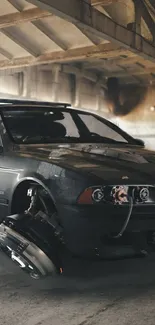 Sleek dark gray car parked in an industrial urban setting.