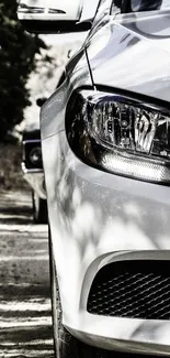 Close-up of a sleek, white luxury car on a road, captured in a modern style.