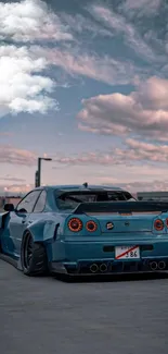 Sleek blue car on an open road beneath a vibrant sky.