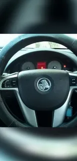 Close-up view of a modern car steering wheel and dashboard.