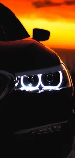 Sleek car silhouette with glowing headlights at sunset.