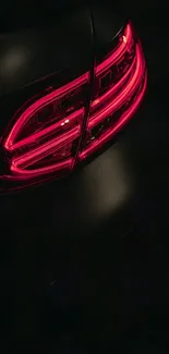 Car taillight glowing red in the dark, sleek and stylish design.