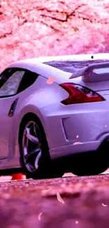 Sleek sports car beneath cherry blossom trees, capturing seasonal beauty.