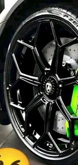 Close-up of a car wheel with a black rim and green brake caliper.