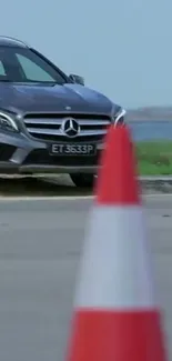 Mercedes parked near a red cone, scenic view.