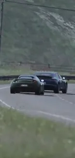 Two sleek cars driving on a scenic, curvy road.