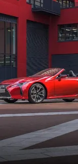 Red convertible car in urban architectural setting.