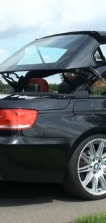 Sleek convertible car with retractable top against a natural backdrop.