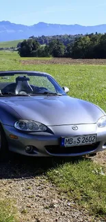 Convertible parked in scenic countryside landscape.