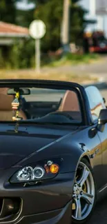 Sleek convertible car on urban street wallpaper.