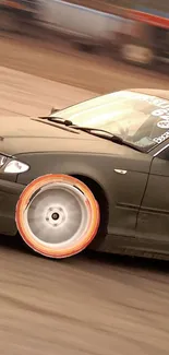 Drifting car with vibrant wheel on a race track.