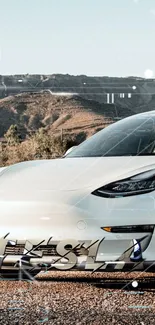 White Tesla car with mountain backdrop in mobile wallpaper.