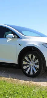 Modern electric car on a scenic route under a blue sky.