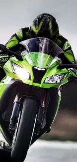 Green sports bike with rider on a racetrack, showcasing speed and dynamic action.