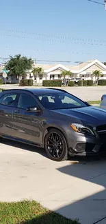 Sleek gray luxury car parked in driveway.