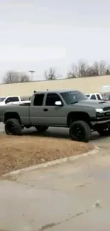 Grey pickup truck in urban parking lot setting.