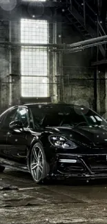 Sleek black car in an industrial setting wallpaper.