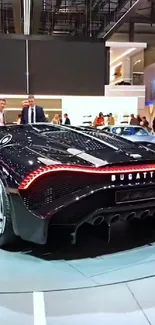 Sleek black Bugatti luxury car showcased at an exhibition.