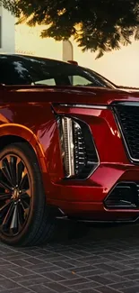 Luxury red SUV in a modern outdoor setting at dusk.