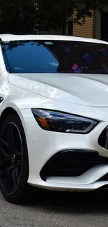 Sleek white luxury car parked on an urban street.