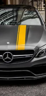 Sleek Mercedes car with yellow stripe on an urban background.