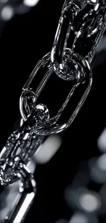 Close-up of a metallic chain with a sleek design on a dark background.