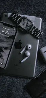 Dark-themed Apple gadgets wallpaper including iPhone, iPad, and Apple Watch.