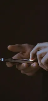 Hands holding a sleek smartphone in dark mode, perfect for a minimalist look.