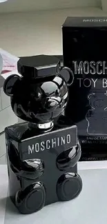 Black Moschino bear sculpture with sleek design on a table.