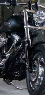 Sleek black motorcycle parked in an industrial garage setting.