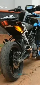 Motorcycle with blue accents seen from rear on dirt track.