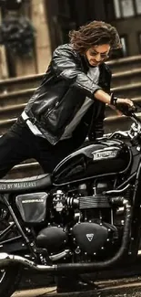 Leather-clad rider on a classic black motorcycle in front of steps.