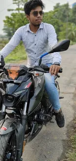 Man rides motorcycle down scenic road with lush greenery.