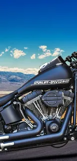 Motorcycle on open road under a blue sky with desert landscape.