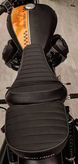 Sleek black motorcycle seat with orange stripe.