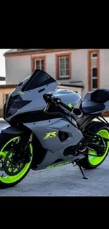 Sleek gray motorcycle with neon wheels on street background.