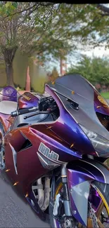 Purple motorcycle on a street with trees.