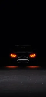 Dark wallpaper with glowing car headlights.