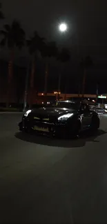 Black sports car on dimly lit road with palm trees at night.