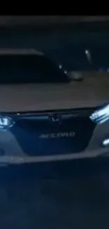 Sleek car driving at night with glowing headlights.