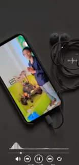 Smartphone with earphones on a dark background, playing a video.