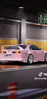 Sleek pink car driving through a city tunnel at night.