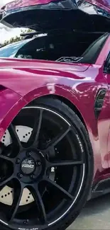 Sleek pink sports car with black rims, perfect for mobile wallpaper.