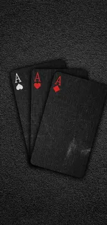 Black playing cards with red accents on a textured dark background.