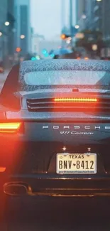 Porsche on a rainy city street at night, showcasing urban elegance.