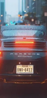 Porsche car driving through a city at night with glowing brake lights.