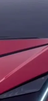 Close-up view of a sleek red car with modern angular design.