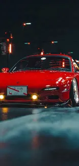 Red sports car illuminated in city nightscape wallpaper.