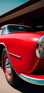 Close-up of a sleek red classic car's front view, perfect for mobile wallpaper.