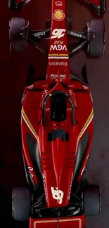 Top view of a sleek red racing car on a dark background.